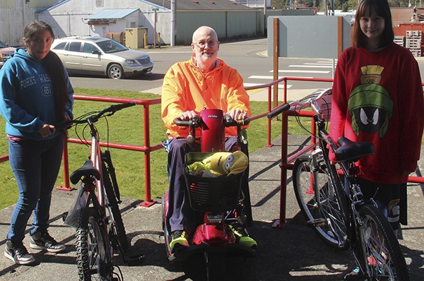 Brenda Calmo-Ordonez and Karma Lapin pose with Scott Seaman. Both girls are in the eighth grade and neither one had a bike. The bike that was auctioned off for $275 at the QVSA was donated by Forks Outfitters.