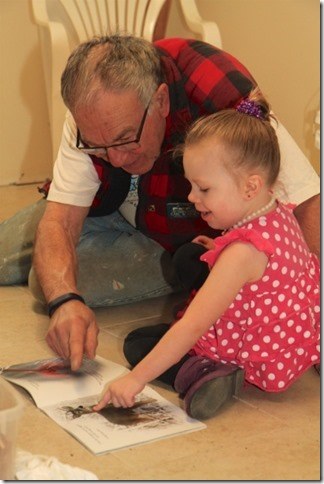 Bianca Gooding succumbs to the magic of Care-A-Vanner Carl Schmidt and settles momentarily on the kitchen floor to explore a favorite book.