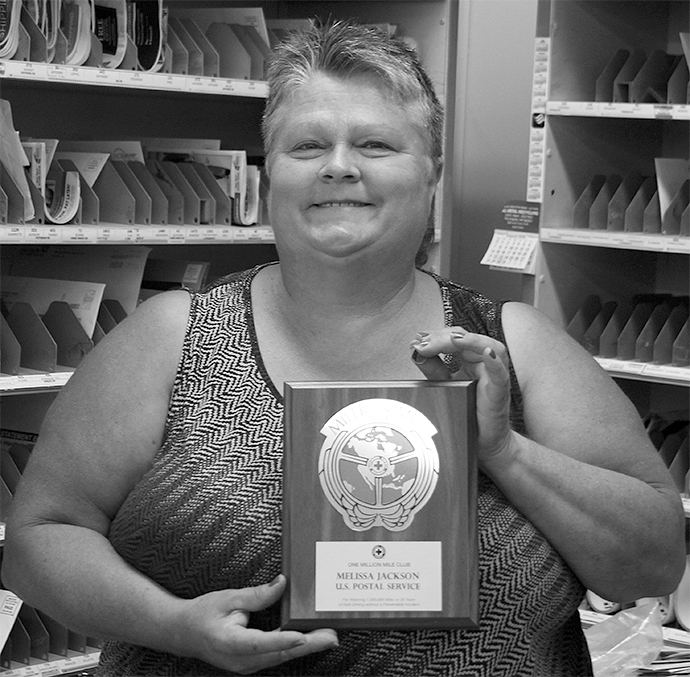 Melissa Jackson took a moment from sorting mail on Monday morning to receive a plaque and a 30-year pin