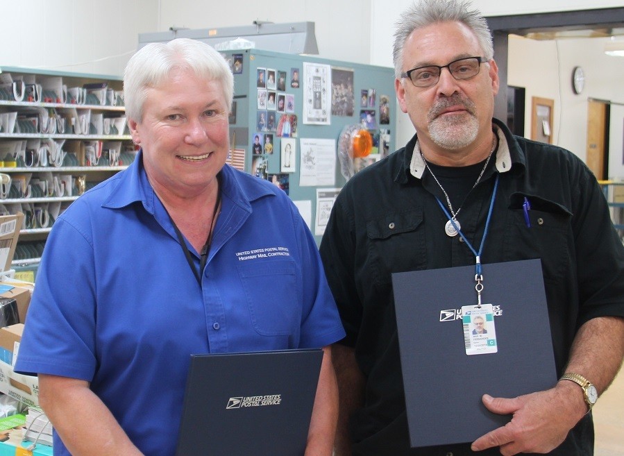 Patty Adams and Max Fernandes take a quick break for a photo, with their awards, before they head out on their daily rounds. Photo Christi Baron