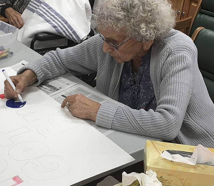 Pauline Adams coloring thank you signs for the 4th of July parade.