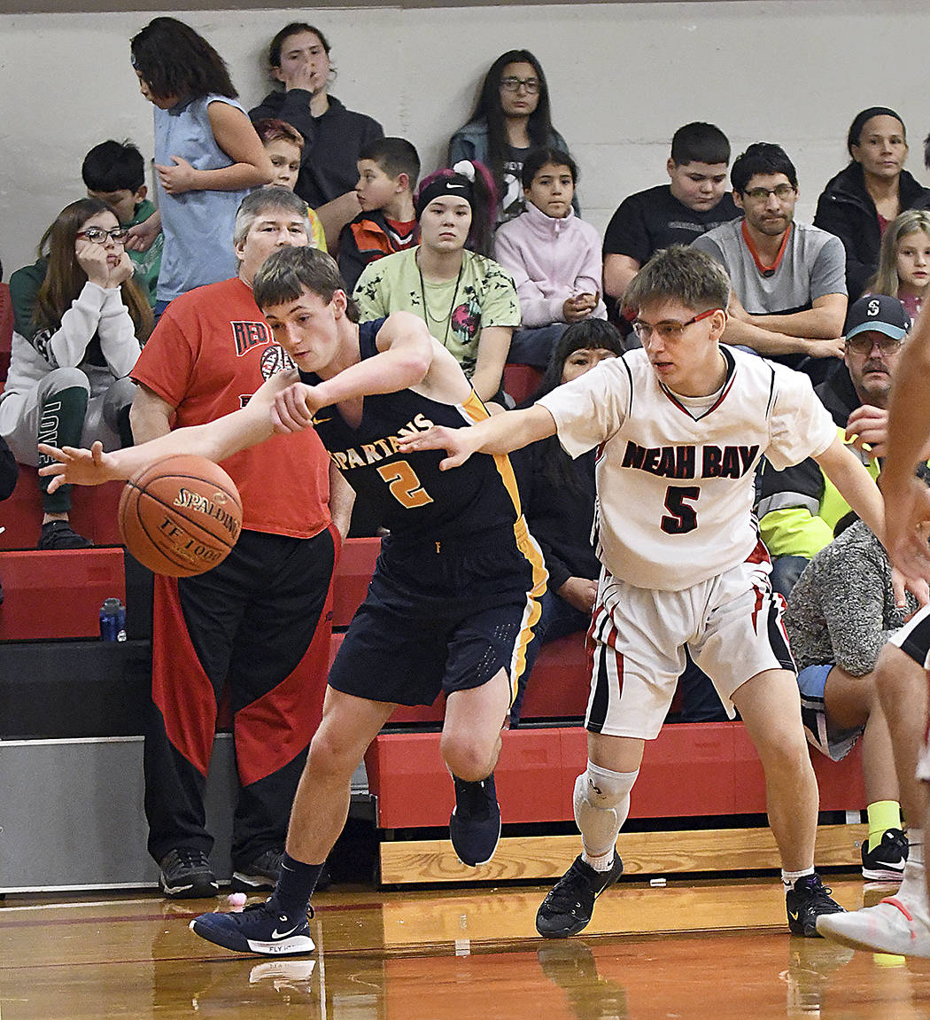 Raymond Davis of Forks loses possession as Neah Bay’s Darren Horejsi defends on Thurday in Neah Bay. The Spartans won their game 49-36. photo by Mike Salsbury for The Forks Forum