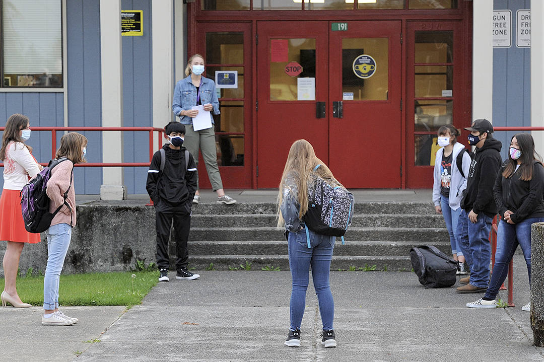 Masked students await the opening of the door to the Forks Junior High school Monday, Oct. 5 for the first day of school held in the building since last spring’s school classes. Photos by Lonnie Archibald