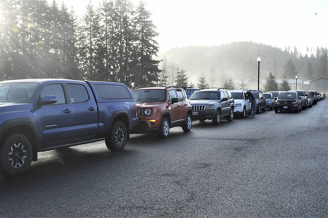 Vehicles line up at the Forks Transit Center beginning at 8:30 a.m. Friday, Jan. 15, as the Peninsula College parking lot was by then full as were other parking facilities during COVID-19 Virus vaccinations held at the FHS auxiliary gym. Photo by Lonnie Archibald