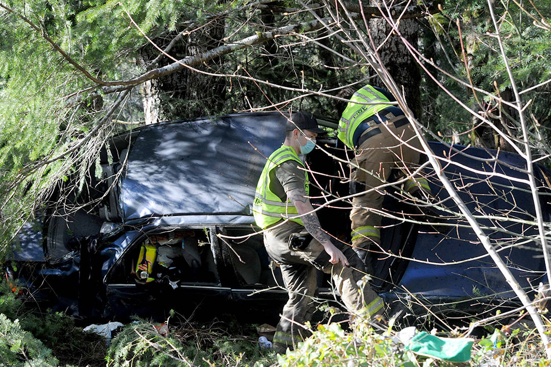 Firemen inspect the vehicle which left highway 101 near mile marker 206 Saturday afternoon. It was reported that law enforcement may have also been looking for another individual who may have left the scene after the accident. Photo by Lonnie Archibald