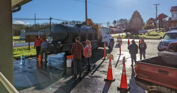 Outside the Clallam Bay Library residents wait to get water from a PUD water truck. Submitted Photo