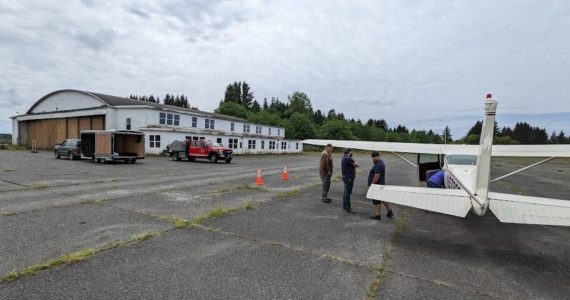 The airplane loaded with food/supplies sits on the runway at the Quillayute Airport as a cargo trailer awaits the loading of items destined for the Forks Food Bank. Submitted Photo