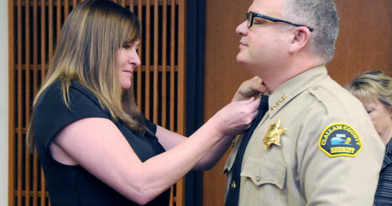 Incoming Clallam County Sheriff Brian King, right, receives his sheriff star from his wife, Brenda King, after he was sworn into office by Superior Court Judge Lauren Erickson on Wednesday at the Clallam County Courthouse. (Keith Thorpe/Peninsula Daily News)