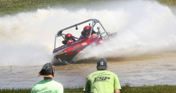 The Fear Not sprint boat driven by Clint Birch and navigated by Terri Lovell speeds through the Extreme Sports Park course as a pair of “island hopper” safety crew members watch the action earlier this year in Port Angeles. (Keith Thorpe/Peninsula Daily News)