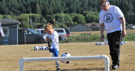 Michael Lacoste, age 4, kicks under the watchful eye of Elks member Chuck Jennings. For Lacoste, it is the proper form and follow-through with the kick.