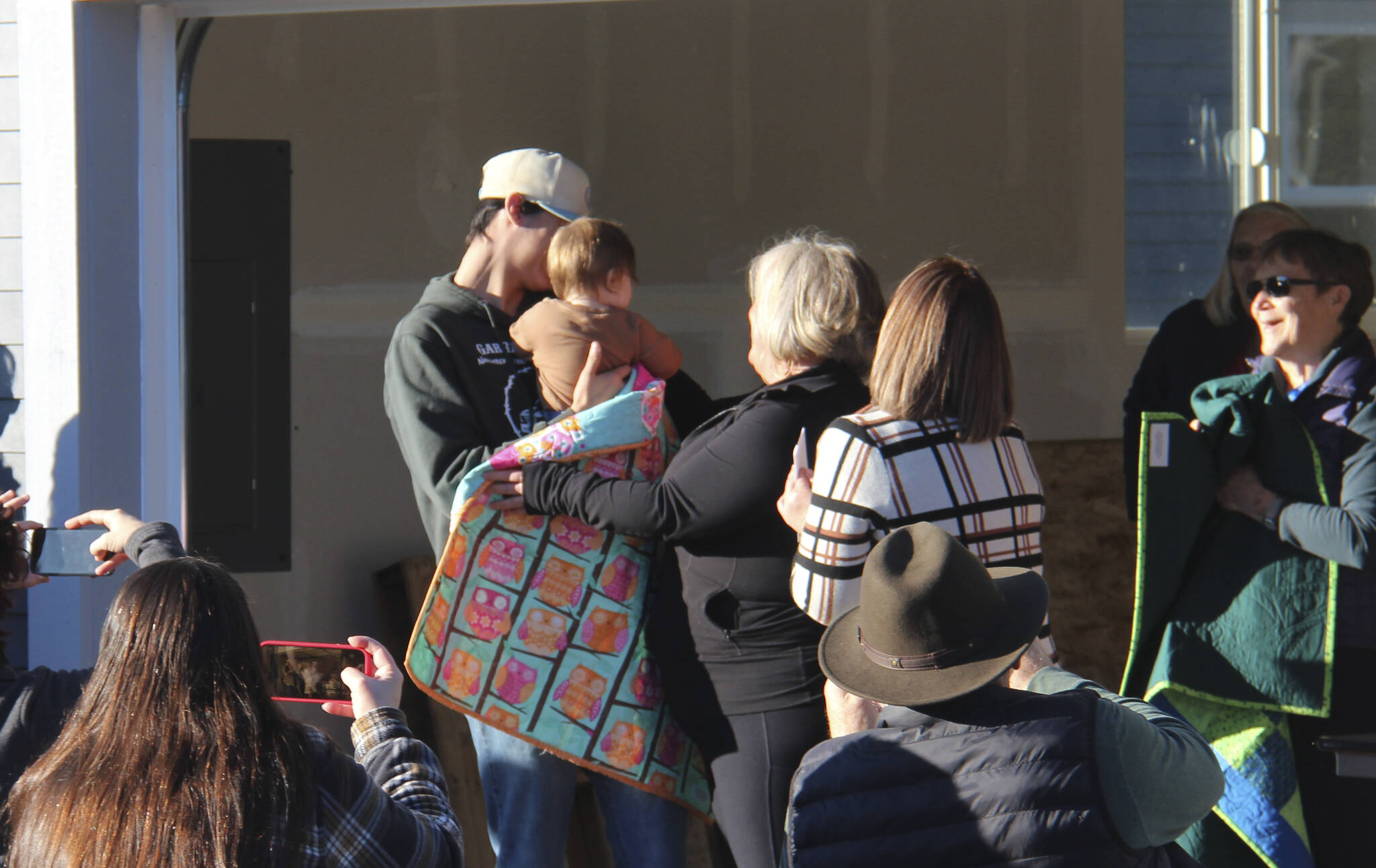 All family members of each family received a quilt. Here Tawnya Rowley, standing nearest back to the camera, looks on as a quilt is wrapped around a family member. Rowley also took a moment to thank her employer, Mariposa House, for working with her schedule so she was able to complete her required hours of work.