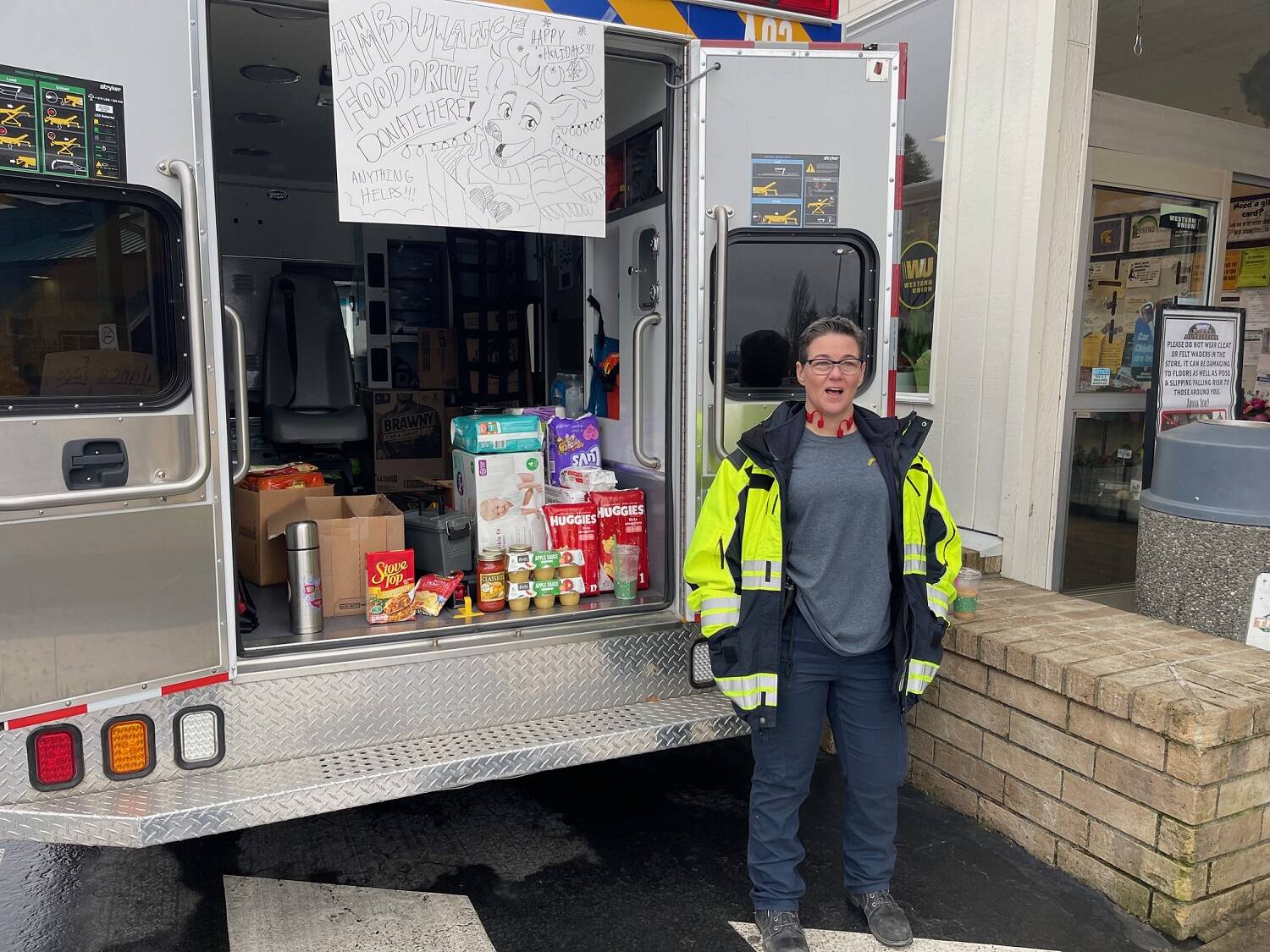 Ambulance crew member Adria Williams was one of several who set up outside Forks Outfitters last week collecting food and cash to benefit the Forks Food Bank. Photo Christi Baron