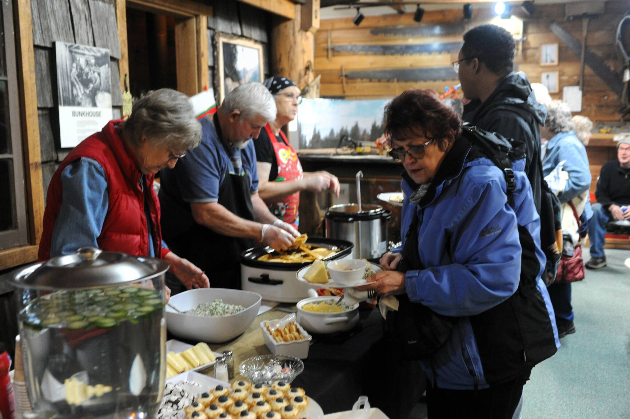 Adria Fuhrman, John Vigil, and Carolyn Self serve a catered lunch at the Forks Timber Museum on Tuesday, Dec. 19. The meal of tamales, soup, salad and desserts was in memory of the late Jack Zaccardo, a WEHS member and local historian who passed in February 2023.