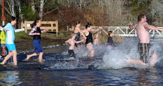 With frost on the lawn, these brave souls entered the cool waters of Lake Pleasant on New Year’s morning in the annual polar bear plunge. Photo by Lonnie Archibald