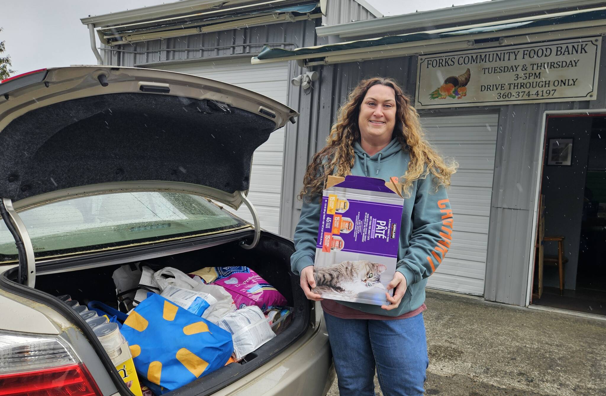 Sena Engeseth, Forks Food Bank, recently accepted donated pet food from Friends of Forks Animals. The pet food was donated by generous community members from the Forks area to Friends of Forks Animals. Submitted photo