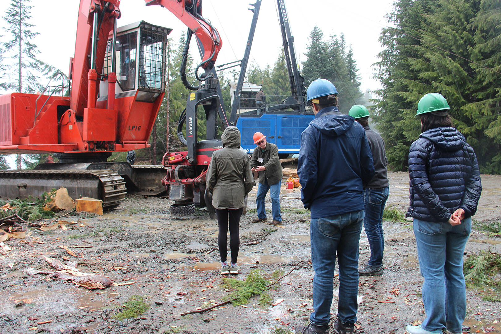 Center of photo Forks Chamber Logging and Mill Tour guide Randy Mesenbrink demonstrates how some of the machinery on the landing works. Tour participants from New York and London look on, last Wednesday on a Dahlgren Logging job on Owl Mountain. Photo Christi Baron