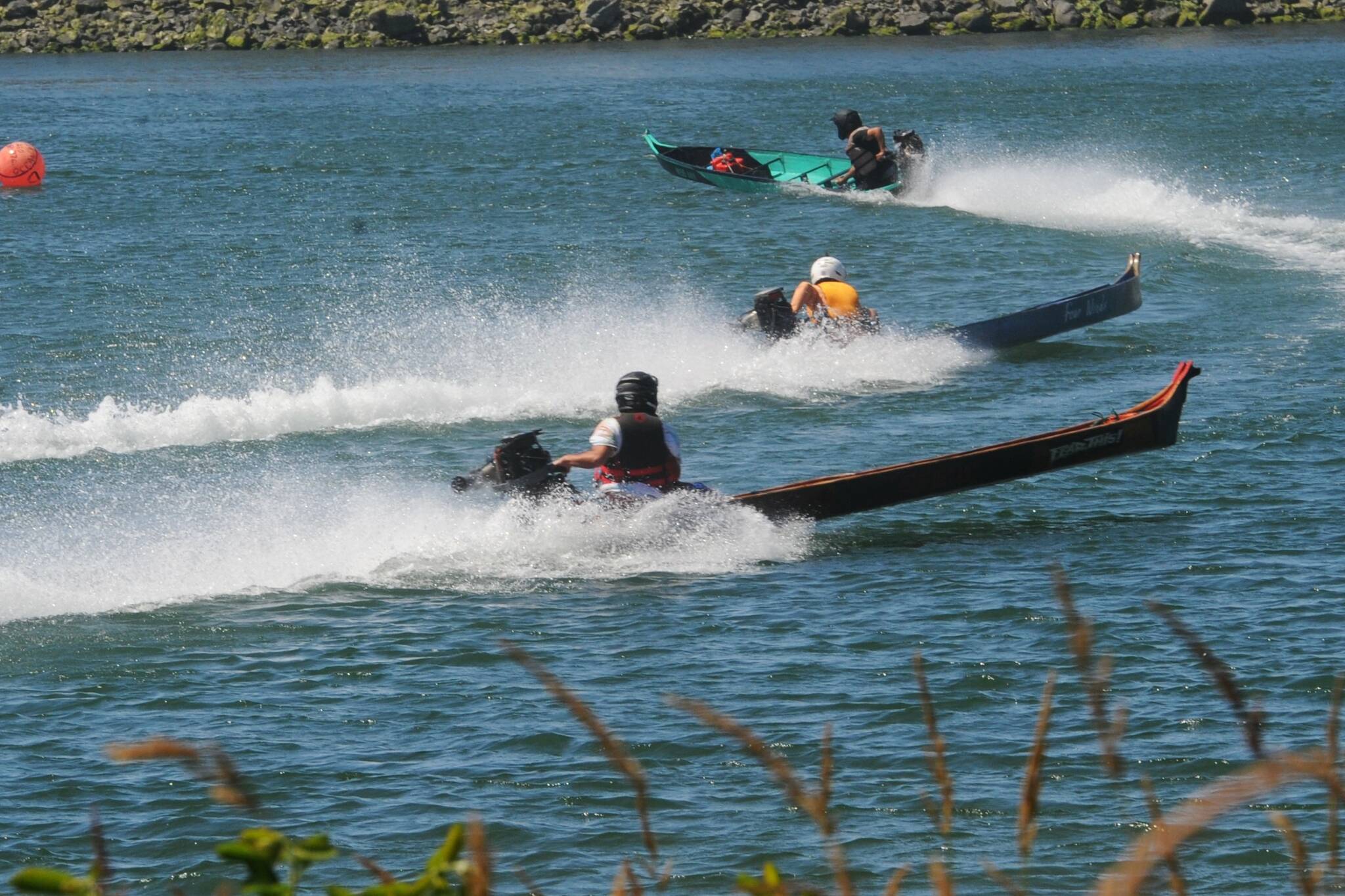 Outboard powered cedar dugout canoes are seen here as they rounded the north turn on the Quillayute River during the Quileute Days celebration. Photo by Lonnie Archibald