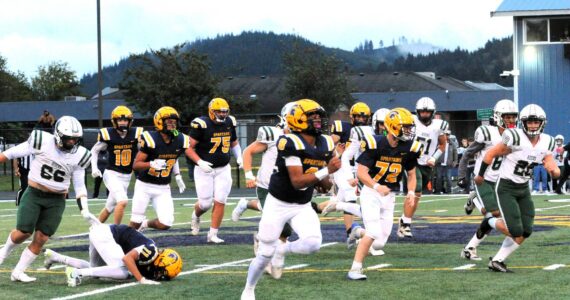 Spartan Emmanuel Hernandez-Stansbury on his long TD run against the Roughriders in the first quarter of play Friday night at Spartan Stadium. Also in the action are Spartans Landen Olson (10), Kaden Ward (23), Cash Barajas (11), Kenny Daman (75), and Jeremy Hutto (72). Forks defeated Port Angeles 13 to 7. Photo by Lonnie Archibald