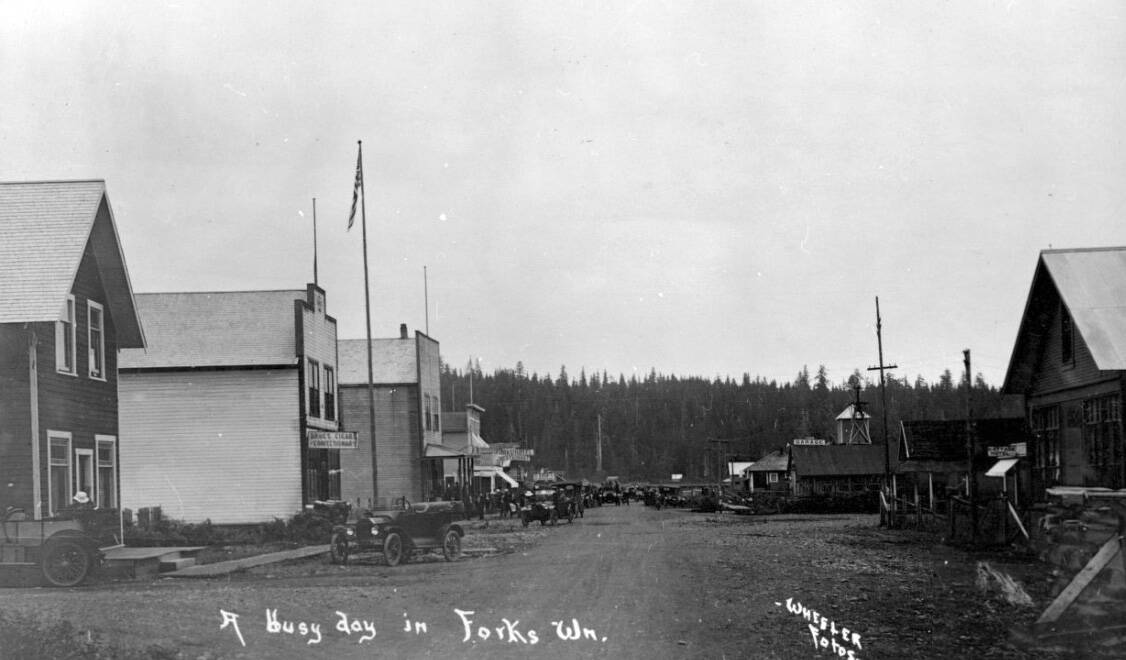 Busy Day? Looking south on Forks’ main street around 1916. Structures that are still standing today seen in the photo are the Ackerly store nearest on the right …now the Sasquatch the Legend Store and further down the street the Palmer House now the Home Slice Take and Bake. Wheeler photo