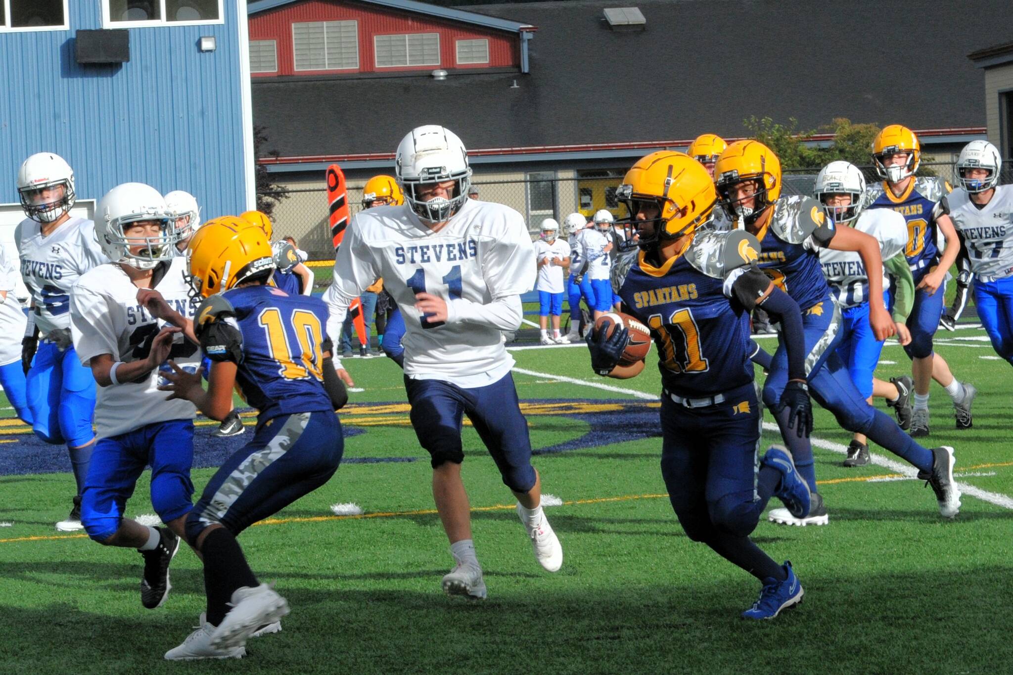 In Forks Middle School football, Stevens of Port Angeles just got by Forks with a 31 to 28 score in this thriller. Pictured here Spartan Pedro Francisco Marcos (11) picked up good yardage behind the blocking of Thomas Penn (10). The next home game is scheduled for Oct. 9 at 4 p.m., against Sequim. Photo by Lonnie Archibald