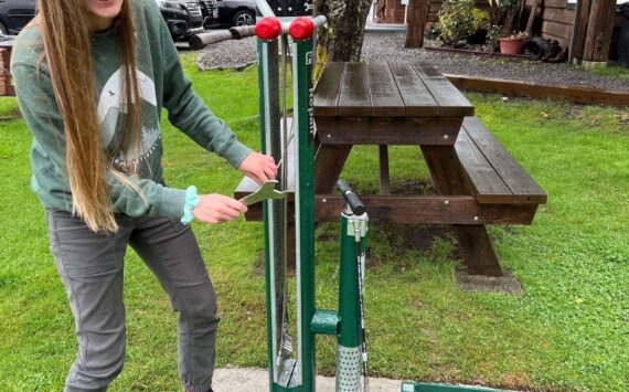 Provided through a grant from the Olympic Peninsula Visitor Bureau, the Forks Chamber purchased a bike rack and repair station for the VIC/Timber Museum grounds. These pieces were added so that bicyclists traveling through could rest and repair their bikes at a safe location. With the help of Olympic Corrections Center Community Crews, they were installed over the last two weeks.
Pictured: Kari Larson, Forks Chamber Director of Customer Service, inspects the new additions! Submitted photo