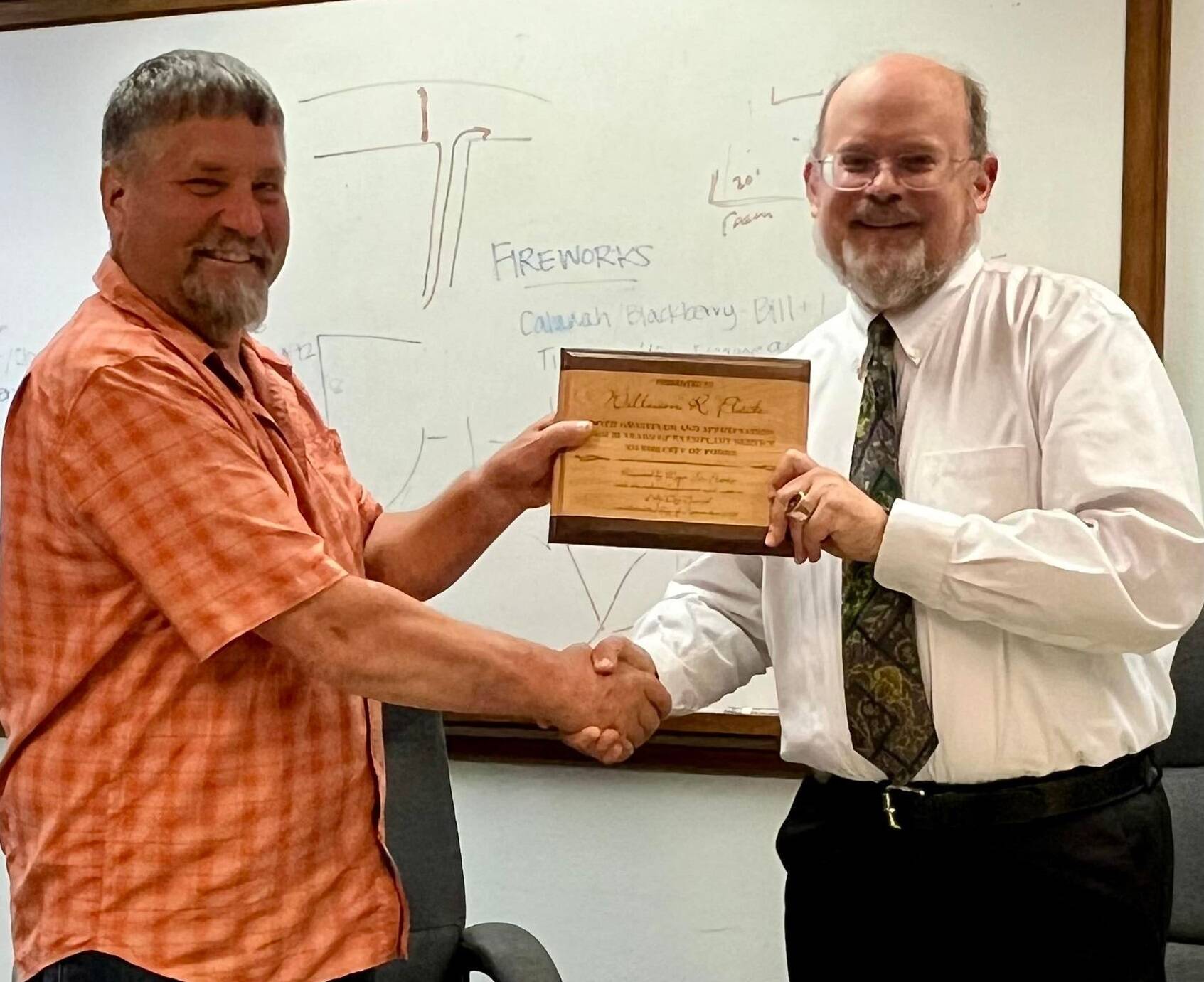 At the Monday, Sept. 23, 2024 Forks city council meeting City attorney/planner Rod Fleck was recognized for his 30 years of service to the city of Forks. In addition to his regular duties, through the years Rod has supported West End interests in timber-related issues; attending countless meetings. He has been a board member and volunteers for many local non-profits as well as teaching classes at Peninsula College -Forks extension site.
Here Forks Mayor Tim Fletcher on the left presents Rod with a plaque in thanks for his time with the city. Submitted photo