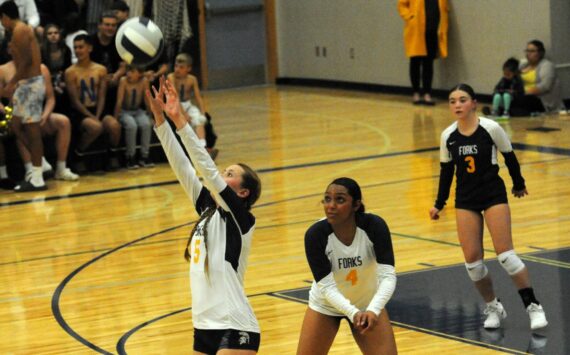 Spartan Reagan Dunn (5) hits while teammates Eladia Hernandez-Stansbury (4) and Kylie Hull look on. Forks defeated Chief Leschi 3 to 0 in the Spartan Gym on Oct. 3. Photo by Lonnie Archibald