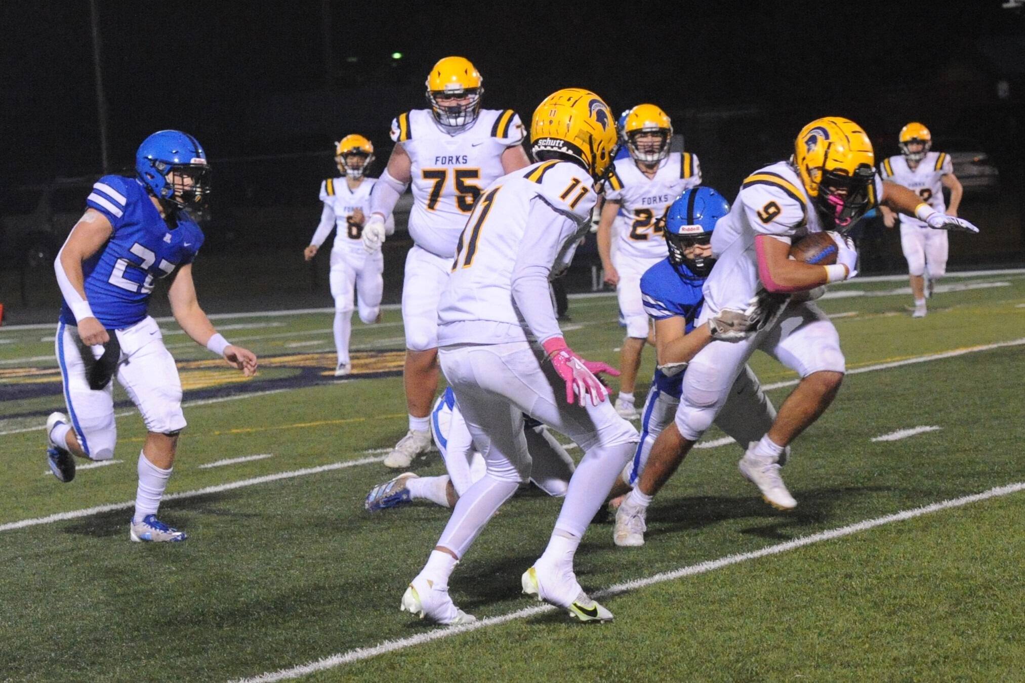 Forks’ Kade Highfield pulls a defender with him Friday October 11 during homecoming where the Spartans fell to the Adna Pirates in this league contest. Also in the action are Spartans Bubba Hernandez-Stansbury (8), Kenny Daman (75), Cash Barajas (11), Kingston Steffen (24), and Jeremy Hutto (72). Photo byLonnie Archibald