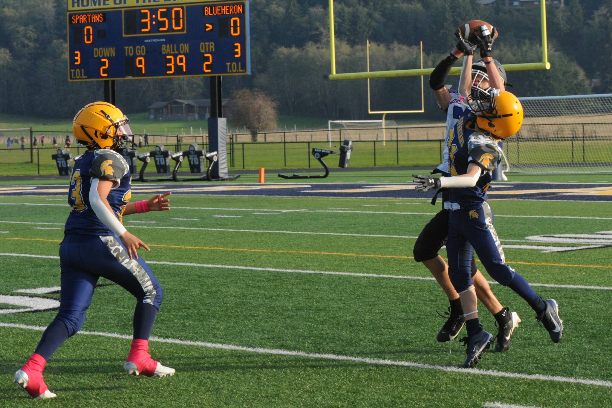 Defending against a Blue Heron pass at Spartan Stadium are Forks’ Kevin Davila Perete (left) and Brady Gillett. Photo by Lonnie Archibald