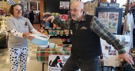 All Darren Sackett, from Forks Outfitters, needed was a drumroll as he struck a dramatic pose as he drew the winning ticket for the Friends of Forks Animals Halloween Basket. Betsy Cadwell, FOFA member, is assisting. The lucky winner was Mary Ulin!
The basket and contents were donated by FOFA members Karen Clark and Deb Pavlich Boaz.
Thanks to everyone who bought tickets!! Submitted photo