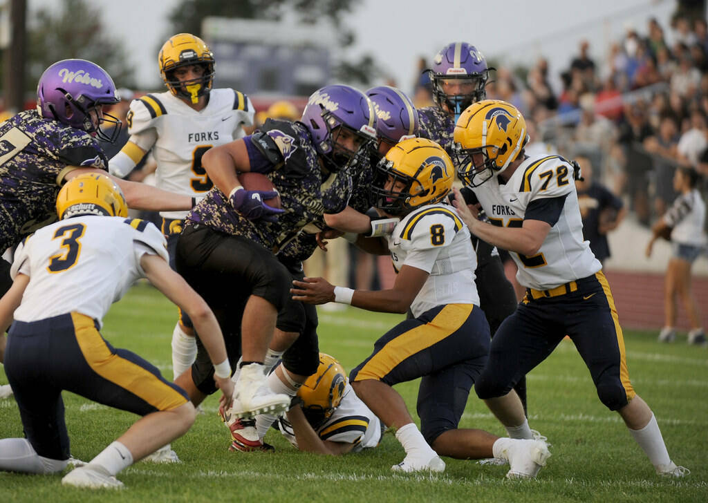 Michael Dashiell/Olympic Peninsula News Group Sequim’s Lars Wiker, with ball, is tackled by, from left, Forks’ Gage Willenbrink, Bubba Hernandez and Sawyer Graham. Hernandez, Graham and Willenbrink were all honored in all-league voting by Class 2B Central League West Division coaches.