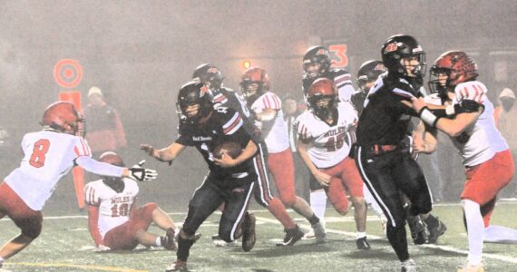 Red Devil Jodell Wimberly (1) makes his way through the fog and past Mule defenders en route to a touchdown Friday evening in Forks where Neah Bay defeated Wahkiakum 70 to 14 to advance in the 1B state playoffs. The Red Devils will face Almira Coulee Hartline on Saturday, November 23 at Lions Field in Moses Lake at 1 p.m. Photo by Lonnie Archibald