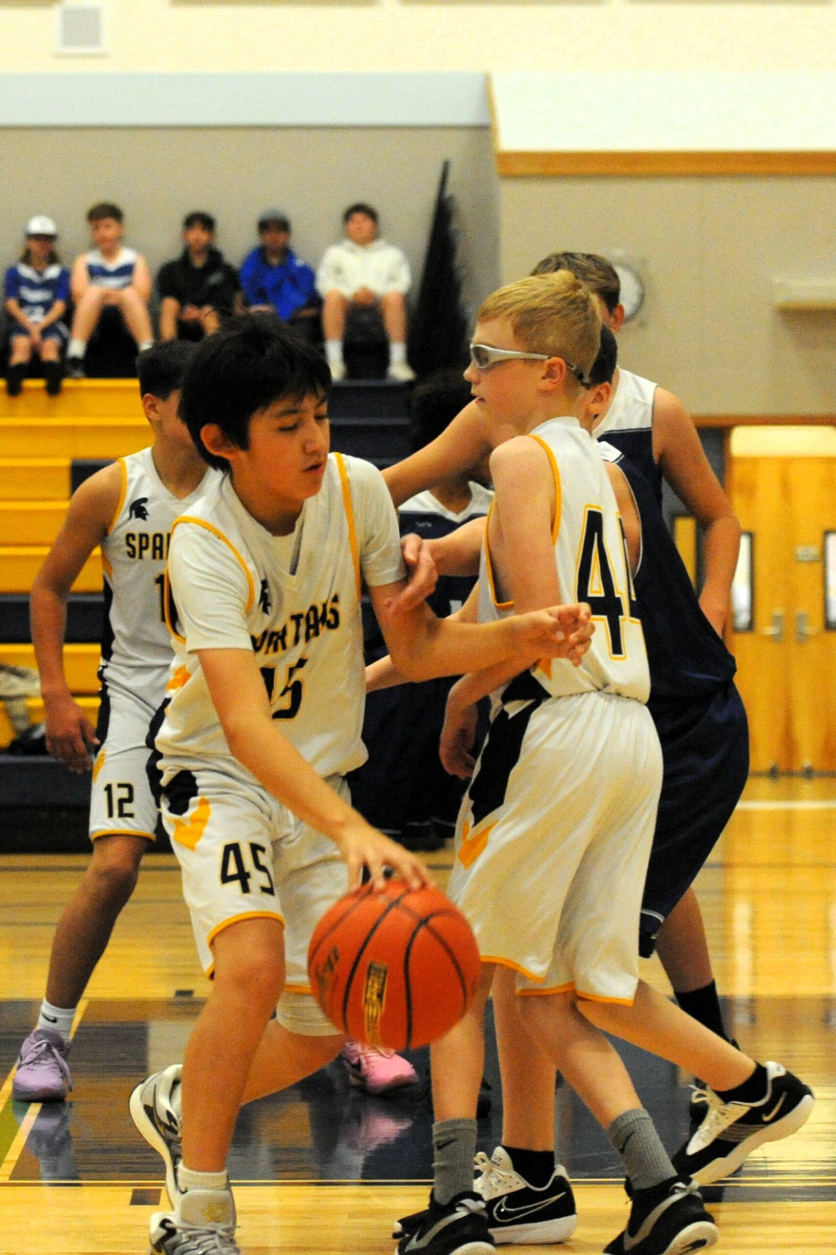 Spartan Shawn Smith (45) drives toward the basket while teammate Wyatt Johnson sets a screen. Also in the action is Ryder Romberg (12) in this 7th-grade game won by Chicacum. Photo by Lonnie Archibald