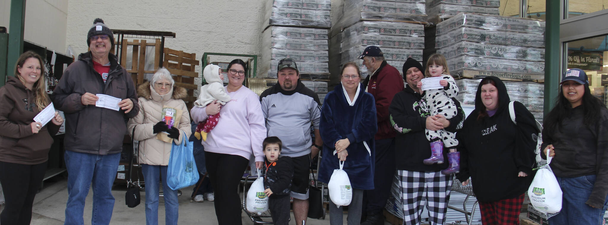 West End Business & Professional Association held its second Turkey Drawing of the season on Saturday outside Forks Outfitters. Winners of turkeys were Sarah Warner, Lori Christenson, and Nani Gomez. Winning Sully’s gift certificates were Christa Baker, Tony Porter, and Hailey Hayden; Cathy Harner won Sasquatch coffee products from the Sasquatch the Legend store. Remember to ask for blue tickets when you shop locally. Bring them to Outfitters on Saturdays for the 1 p.m. drawings. Nov. 23 will be the last of the Turkeys and then Santa Bucks will be awarded Nov. 30, Dec. 7, 14, and 21.
Also, remember to purchase your tickets for the WEBPA $500 shopping spree which will be drawn on Dec. 21. Winner need not be present for the Shopping Spree prize.
Happy winners pose here with their family members! Photo Christi Baron