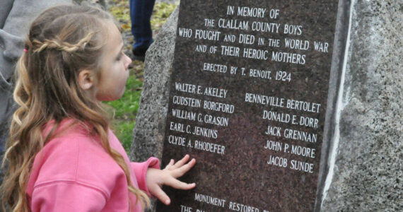 Clara (Rhodefer) Muma, 5, looks at a memorial honoring her great-great-great uncle Clyde Rhodefer of Sequim in front of Carlsborg Family Church on Nov. 9. The plaque was replaced and added the names of the men from Clallam County who died in World War I. (Matthew Nash/Olympic Peninsula News Group)