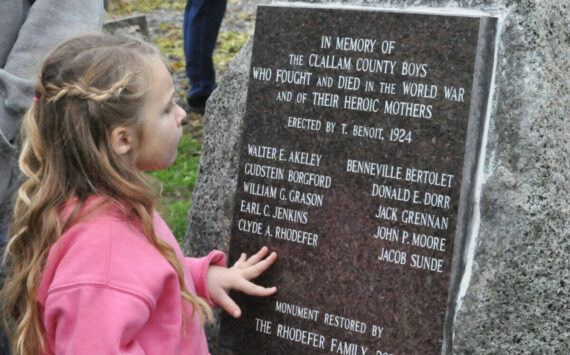 Clara (Rhodefer) Muma, 5, looks at a memorial honoring her great-great-great uncle Clyde Rhodefer of Sequim in front of Carlsborg Family Church on Nov. 9. The plaque was replaced and added the names of the men from Clallam County who died in World War I. (Matthew Nash/Olympic Peninsula News Group)