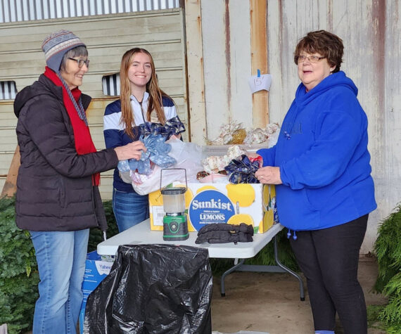 Cindy Mesenbrink and Diane Edwards of Soroptimist, with volunteer honor student Aliya Gillett of FHS, were at Pacific Forest Managements garage on Sol Duc Way Friday Nov. 22, to deliver wreath orders, as part of Festival of Trees. Shown here fluffing the bows! Photo by Katie Krueger