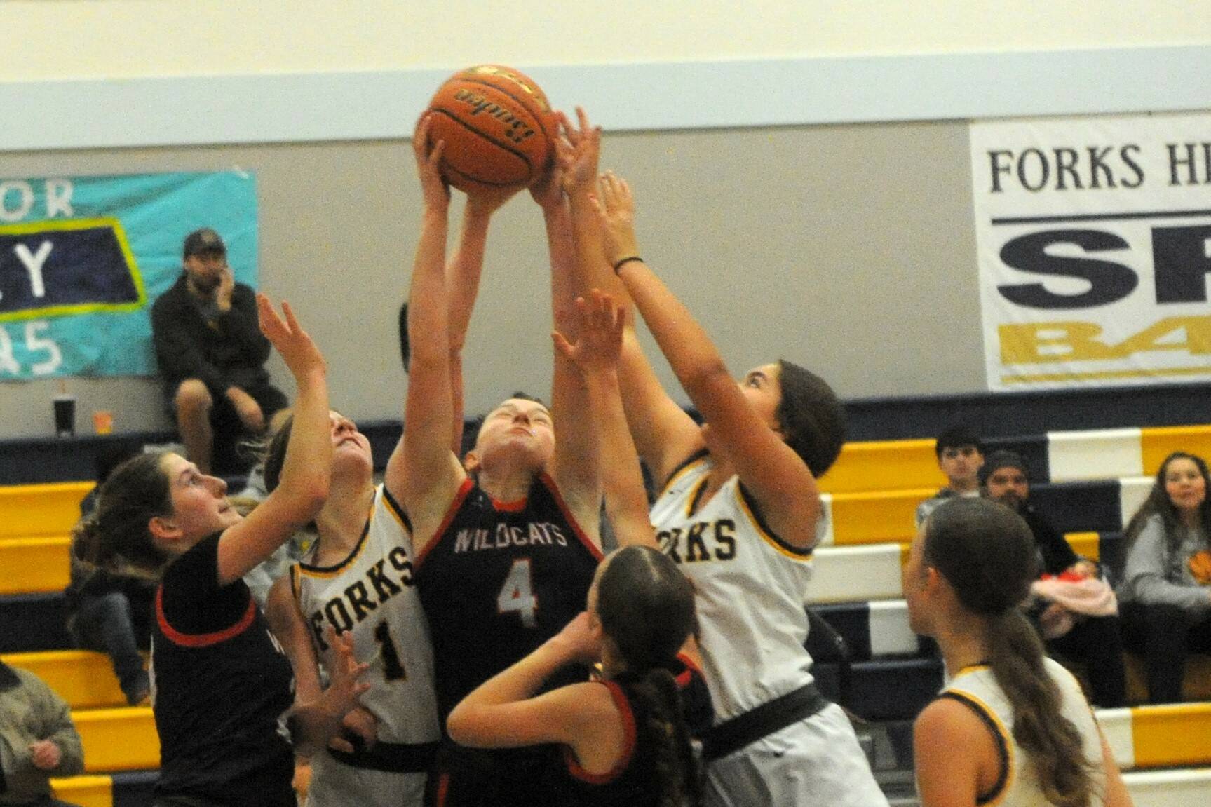 Spartans Bailey Johnson (1) and Pearl Salazar (5) compete with the Wildcats for ball control Saturday afternoon in the Spartan Gym where Forks defeated Crosspoint Christian 59 to 47. 
Photo by Lonnie Archibald