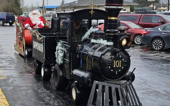 Santa arrived outside Forks Outfitters on Saturday to do the honors at the WEBPA Drawing. Afterward he listened to a few Christmas wishes and handed out a few candycanes. Max Buckner is the creator of the new sleigh and on Saturday Trent Thurman was serving as the train engineer. Photo Robyn Wright