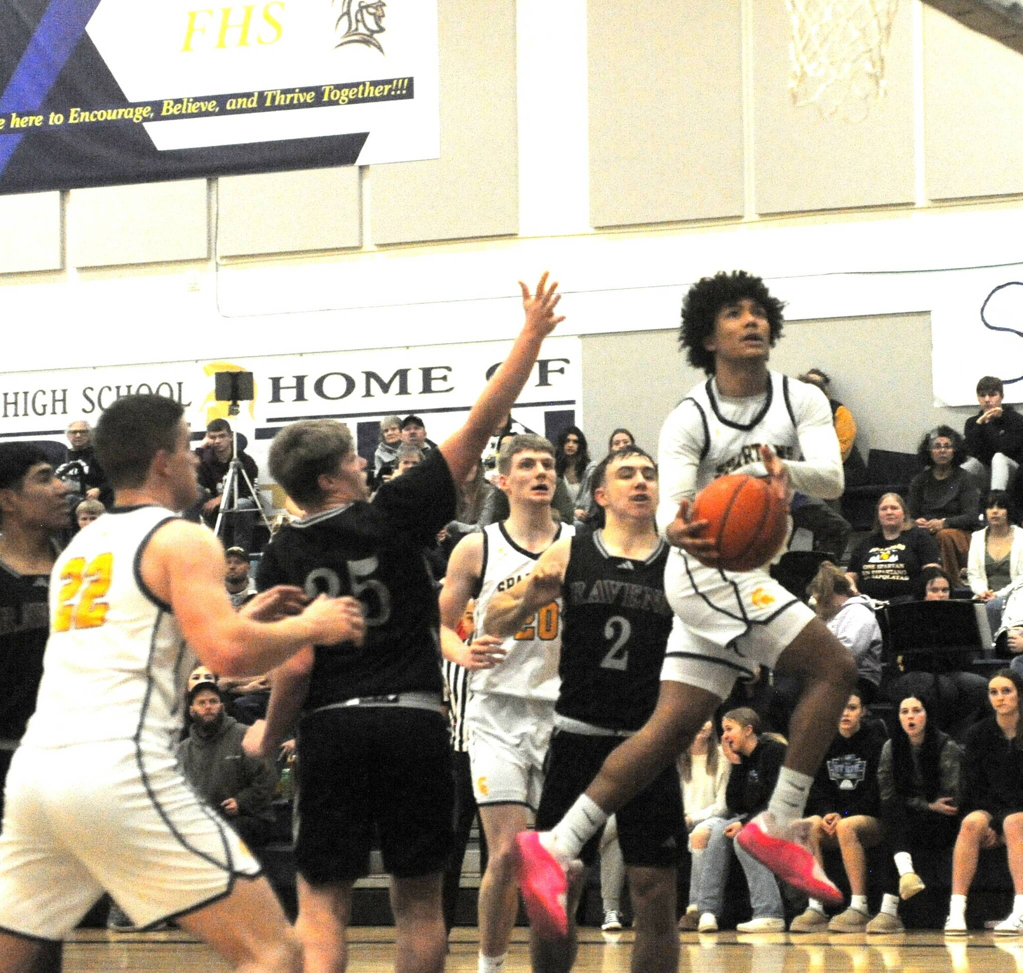 Photo by Lonnie Archibald
Forks’ Bubba Hernandez-Stansbury scores against the Ravens while teammates Brody Lausche and Ty Rowley look on. After three quarters of hard fought basketball, Forks put the game away in the 4th quarter with a tight defense, good rebounding and scoring to take this contest 67 to 45 over league rivals Raymond-South Bend.