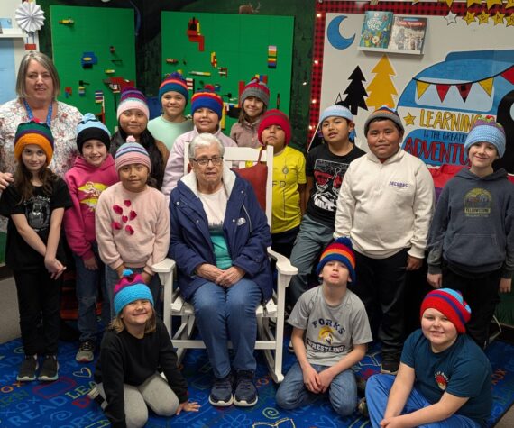 Submitted photo
Cathy Johnson (left) and her mother, Frances Blakely (center), join Forks Elementary School students as they proudly wear the hats they designed. The students, who are now 3rd graders in Mrs. Haag’s class, were recently invited to the FES library to see their creations brought to life and receive their handmade hats.