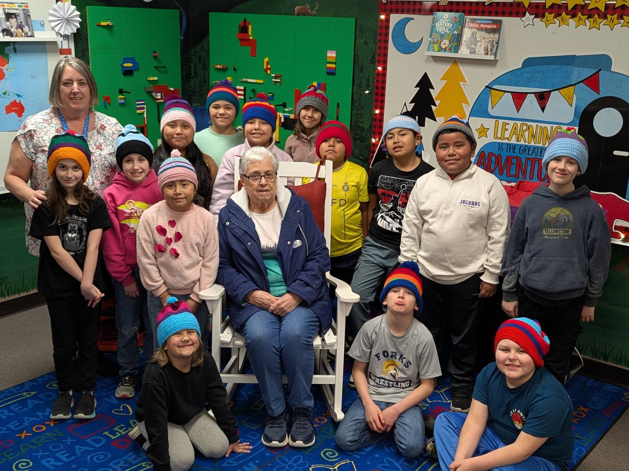 Submitted photo
Cathy Johnson (left) and her mother, Frances Blakely (center), join Forks Elementary School students as they proudly wear the hats they designed. The students, who are now 3rd graders in Mrs. Haag’s class, were recently invited to the FES library to see their creations brought to life and receive their handmade hats.