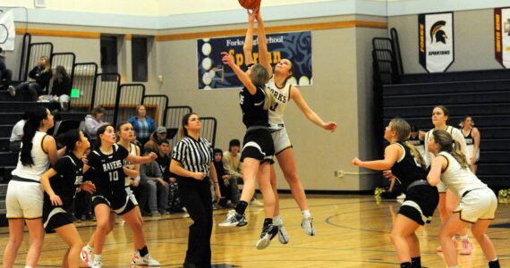 Photo by Lonnie Archibald
Forks’ Avery Dilley jumps against Raymond South Bend in the Spartan gym where the Ravens outlasted the Spartans by way of a 54 to 47 score in Pacific 2B league action. Forks had defeated the Ravens earlier in the season on the Ravens home cout but this contest was reversed as too many turnovers and fouls hampered the Spartan’s chance to win this hard-fought contest, especially in the first half of play. Other Spartans from left are Chloe Gaydeski, Karee Neel, Fynlie Peters, and Bailey Johnson.