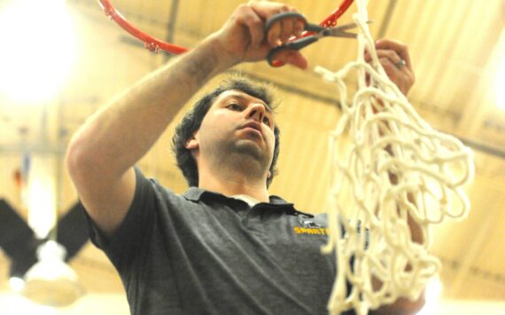 Photo by Lonnie Archibald
Spartan head coach Keith Weekes cut down the remainder of the net after the varsity boys had each taken a strand. The Forks boys won the Pac 2B league with a win over North Beach at home on Senior night.