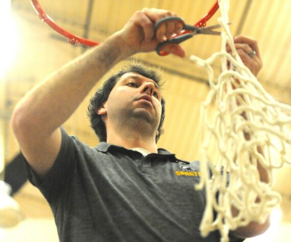 Photo by Lonnie Archibald
Spartan head coach Keith Weekes cut down the remainder of the net after the varsity boys had each taken a strand. The Forks boys won the Pac 2B league with a win over North Beach at home on Senior night.