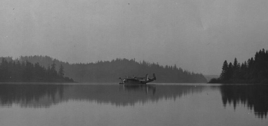 Keen mentioned in the talk float planes on Lake Ozette; here a plane sits on Lake Ozette. During the war many sites along the Sound were scoured for an appropriate small seaplane base, including Lake Ozette, Indian Island, Keystone Harbor, and Penn Cove. The Lake Ozette site never got off the water.